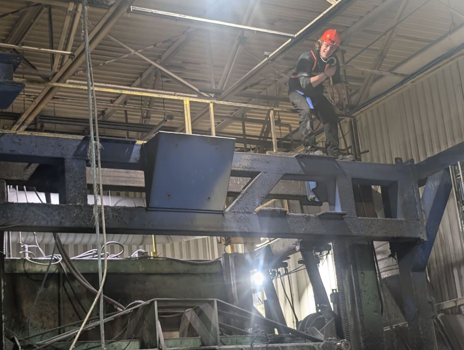Ouvrier en hauteur sur une plateforme industrielle, démantèlement d'une charpente d'acier