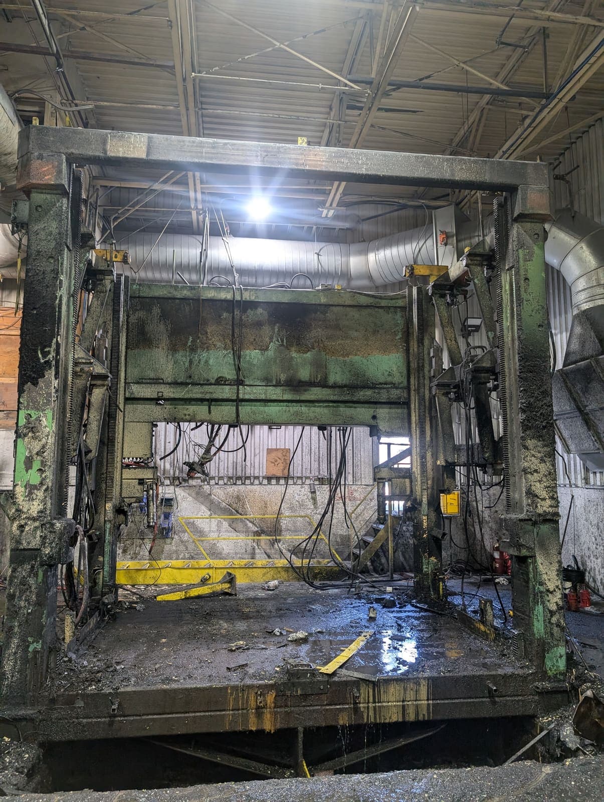 Vue frontale d'une grande presse hydraulique verte avant démolition complète