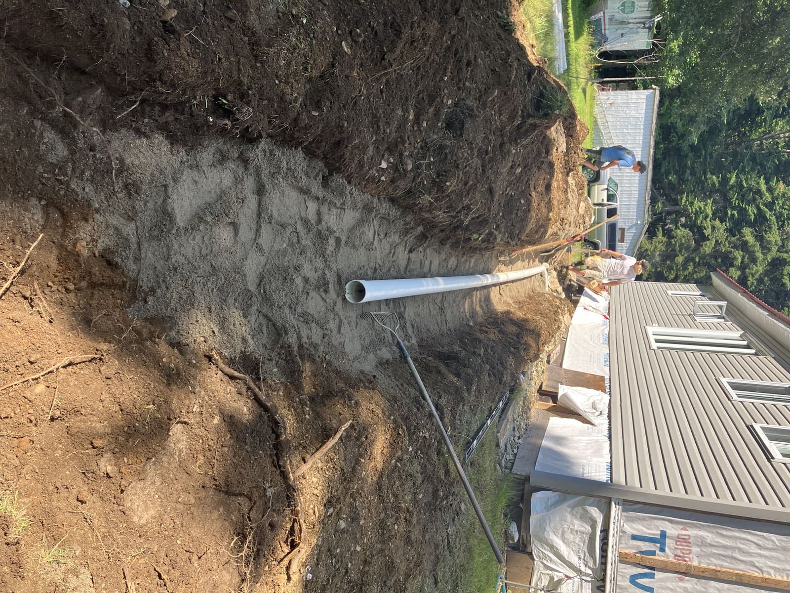 Tranchée de drainage avec conduite PVC en bordure d'une fondation résidentielle