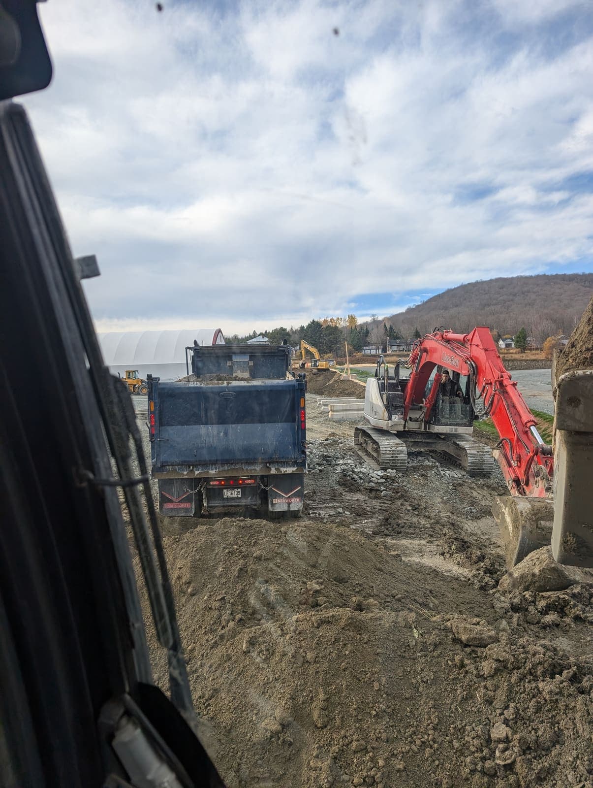 Camion benne et pelle hydraulique en opération sur un chantier de remblai à Sainte-Clotilde-de-Beauce