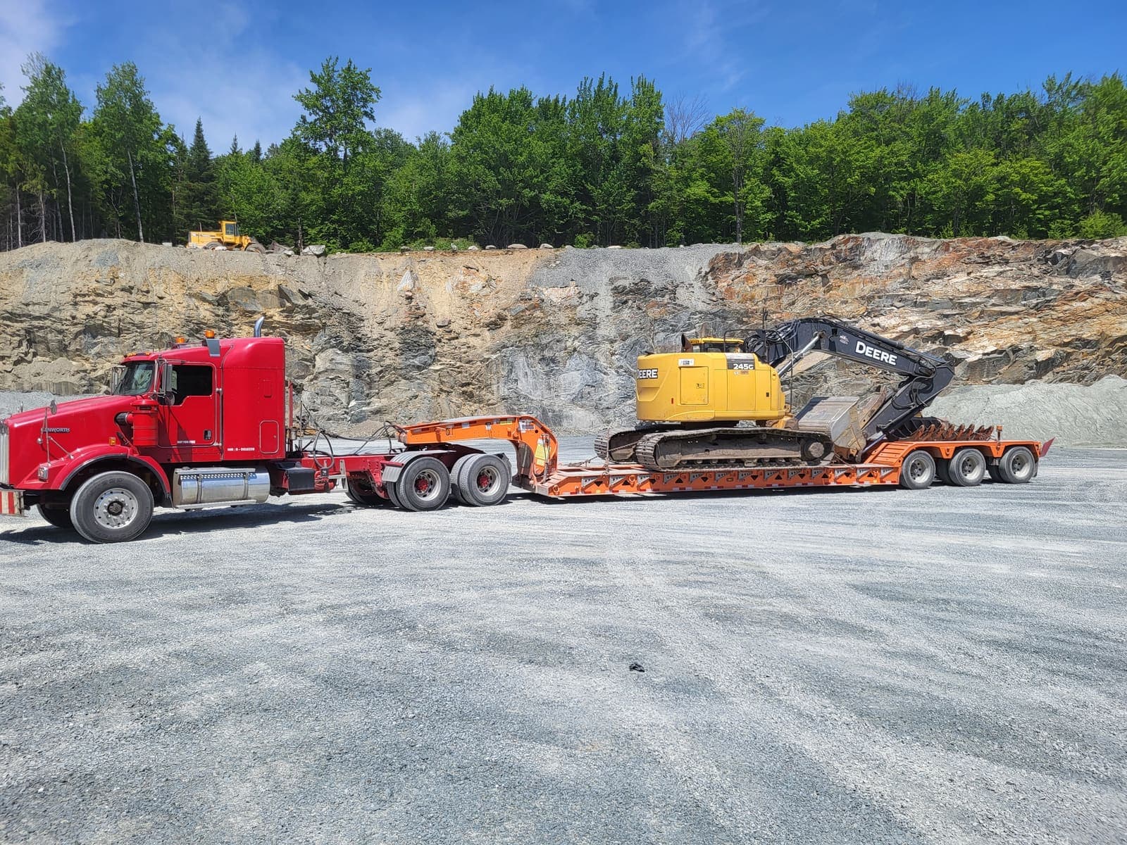Camion fardier rouge avec pelle hydraulique chargée, prêt à l'opération à la carrière