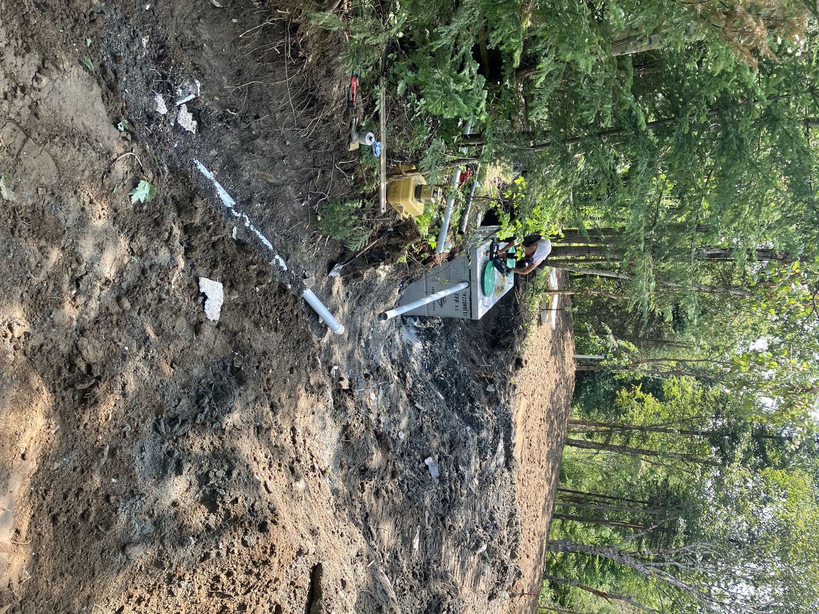 Installation de la fosse septique avec conduite PVC à travers un terrain remblayé