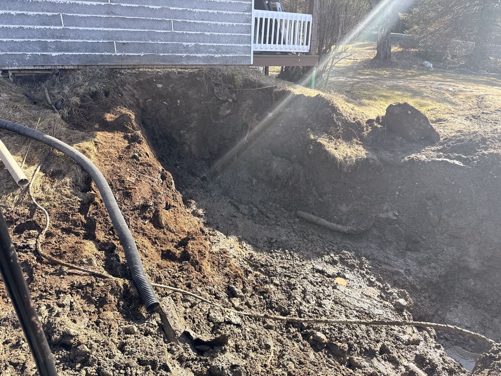 Tranchée d'excavation pour conduites septiques le long d'un revêtement de maison