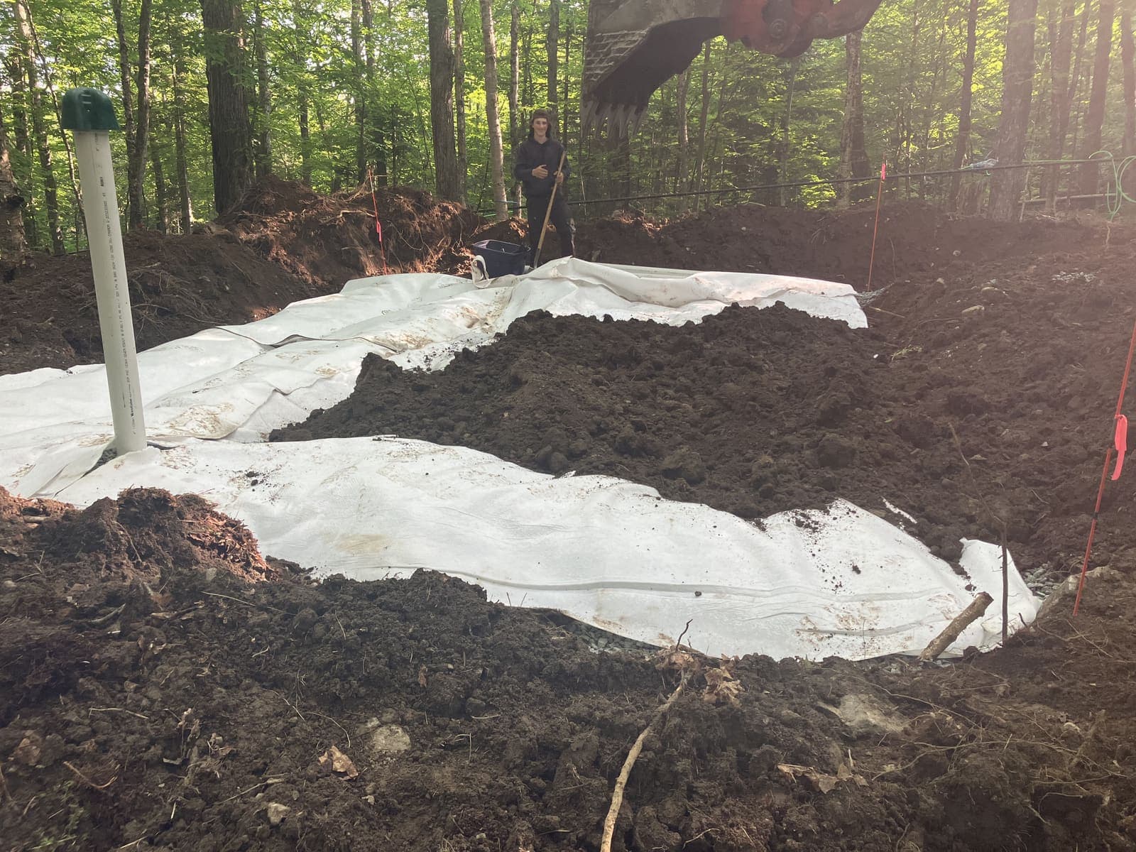 Champ de polissage recouvert de membrane géotextile blanche en milieu boisé