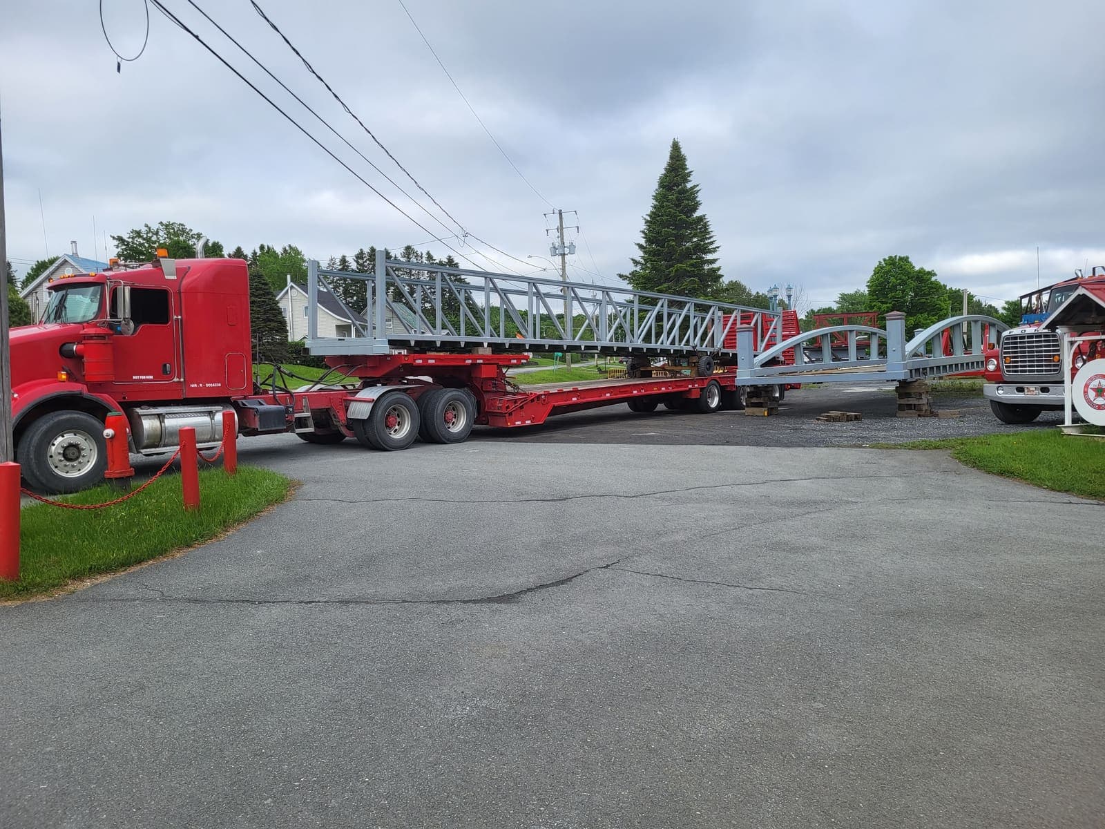 Vue arrière d'un camion fardier transportant une longue charpente métallique grise